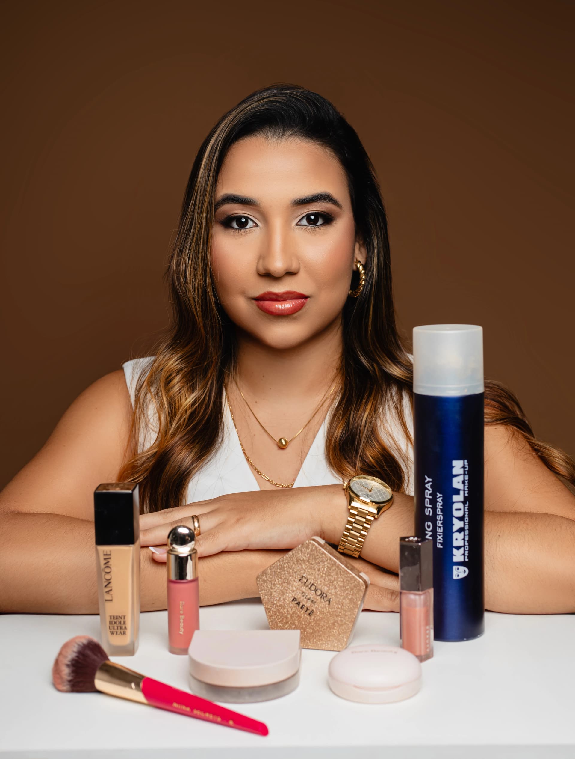 Jaqueline Ferreira, maquiadora profissional, com uma bancada de produtos de maquiagem